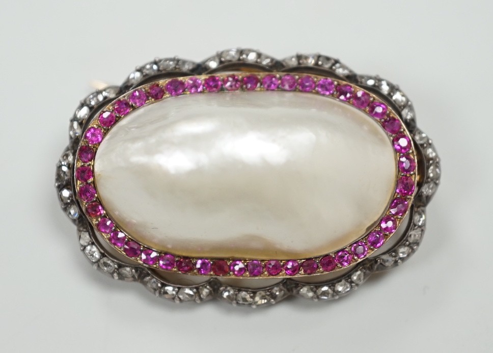 An early 20th century French yellow metal (18ct poincon mark on pin), white metal and mabe pearl set oval brooch, bordered by concentric rows of rubies and rose cut diamonds, 38mm, gross weight 17.3 grams.